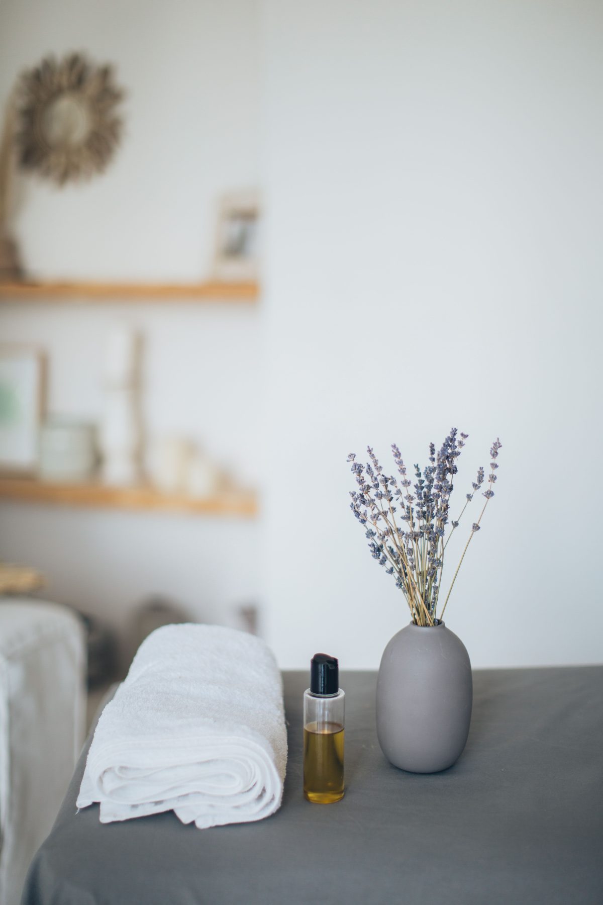 Ambiente relajante con lavanda, toalla blanca y aceites esenciales